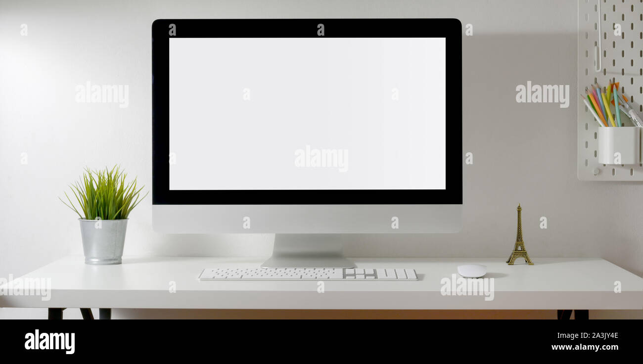 Loft Arbeitsbereich mit Mock up Desktop Computer mit Baum Topf und Dekorationen auf weißem Schreibtisch mit Kopie Raum Stockfoto
