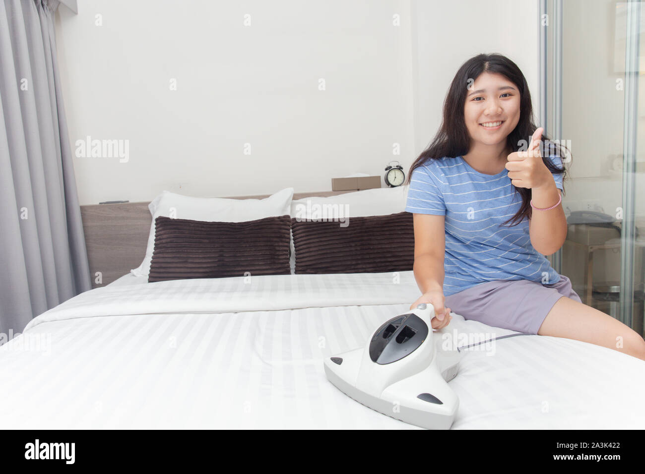 Mädchen Mädchen Reinigung Schlafzimmer mit Bett Vakuum zu saubere Matratzen für gute Gesundheit Allergie von Hausstaubmilben Schutz Stockfoto