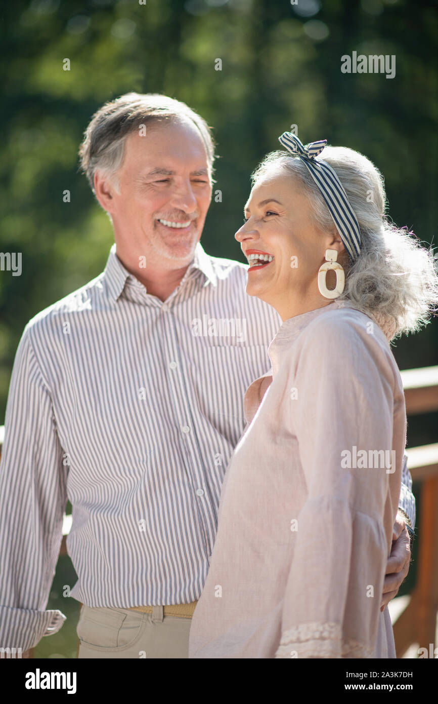 Stilvolle schöne Frau lachend im Gespräch mit Ehemann Stockfoto