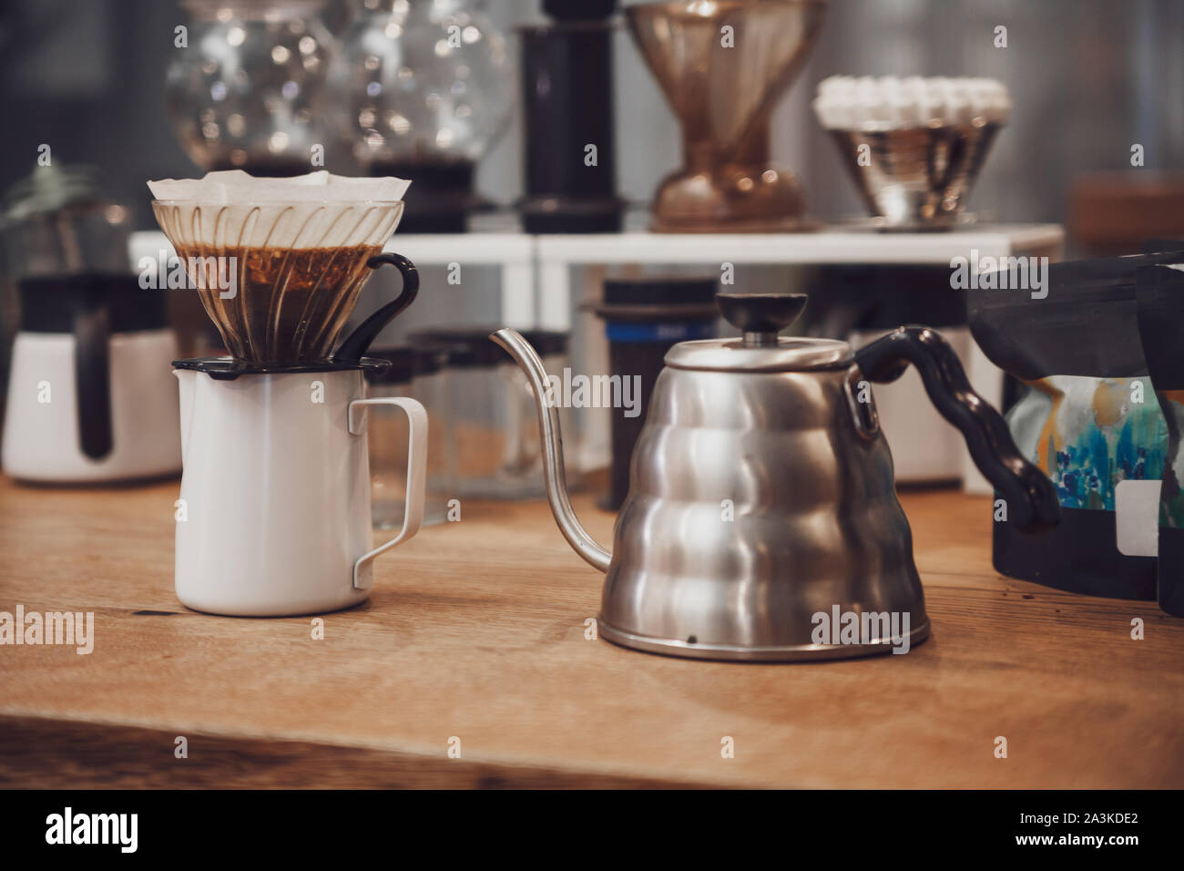 Alternative Kaffee. Trichter mit Filter und Kaffee über den Krug und Wasserkocher aus Metall Stockfoto