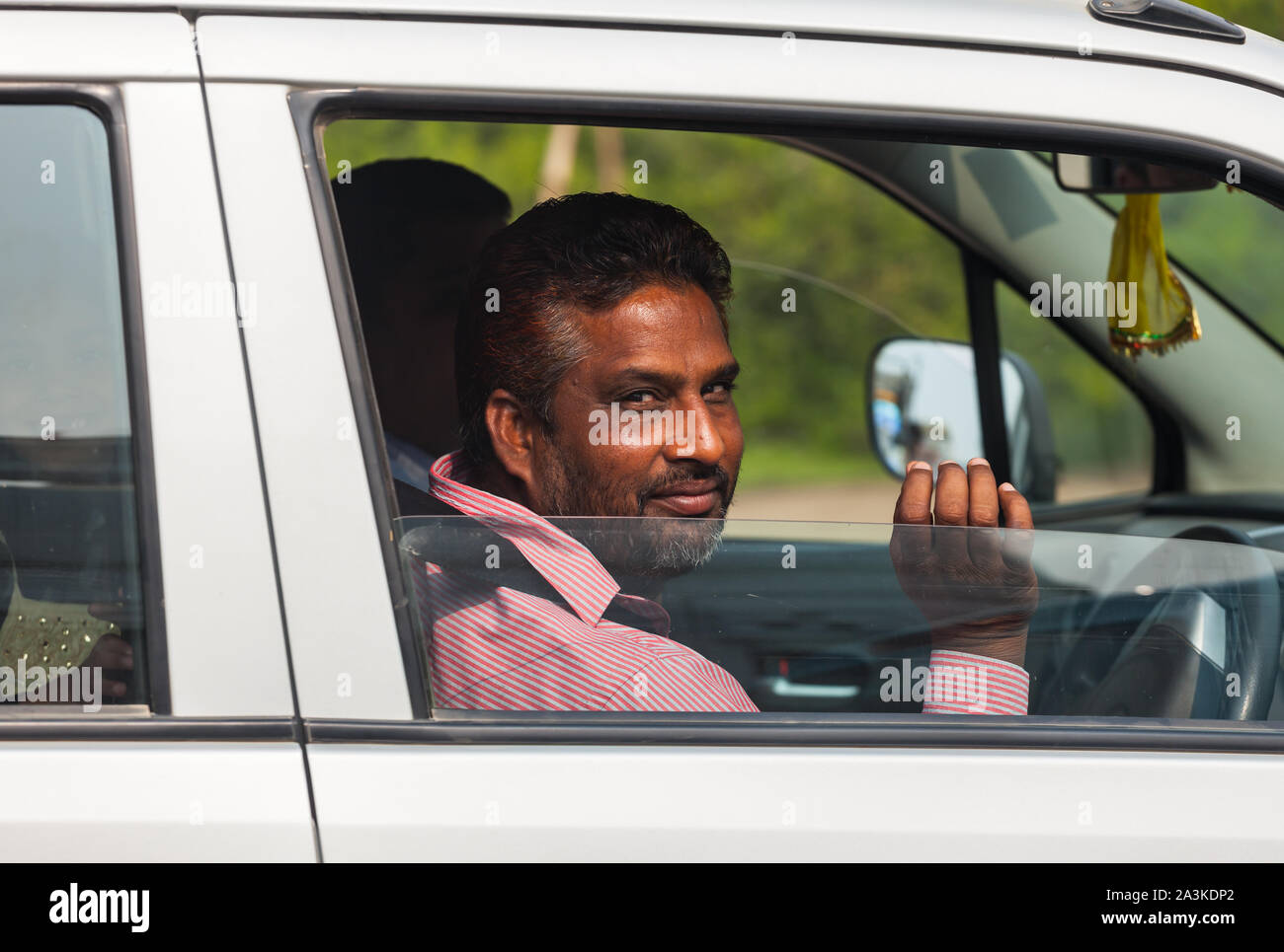 Indischer Mann im Auto lächelnd Stockfoto