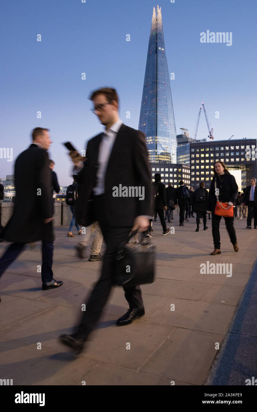 Pendler auf die London Bridge in der Dämmerung, mit dem Shard jenseits, London, England, Großbritannien Stockfoto