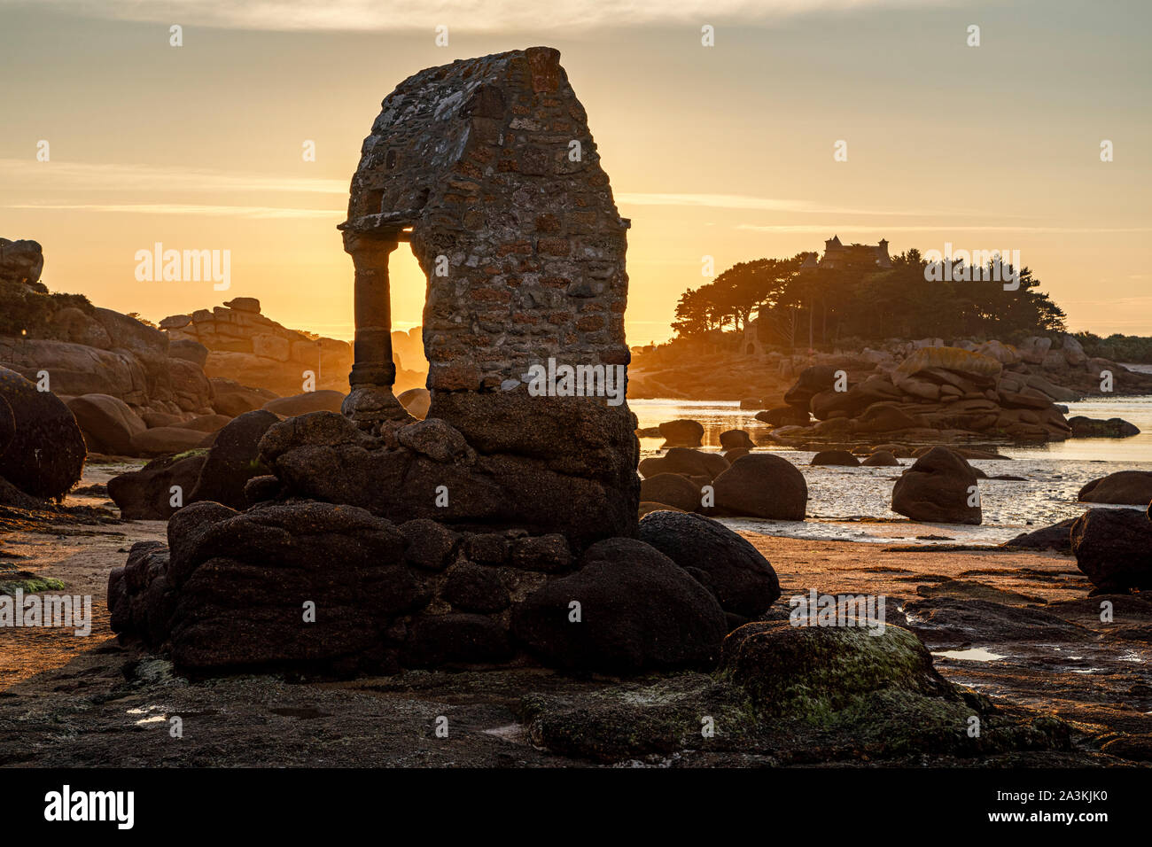Der Schrein des Heiligen Guirec bei Sonnenuntergang und in Richtung Île de Costaérès, Plage de Bretagne, Ploumanac'h, Bretagne anzeigen Stockfoto