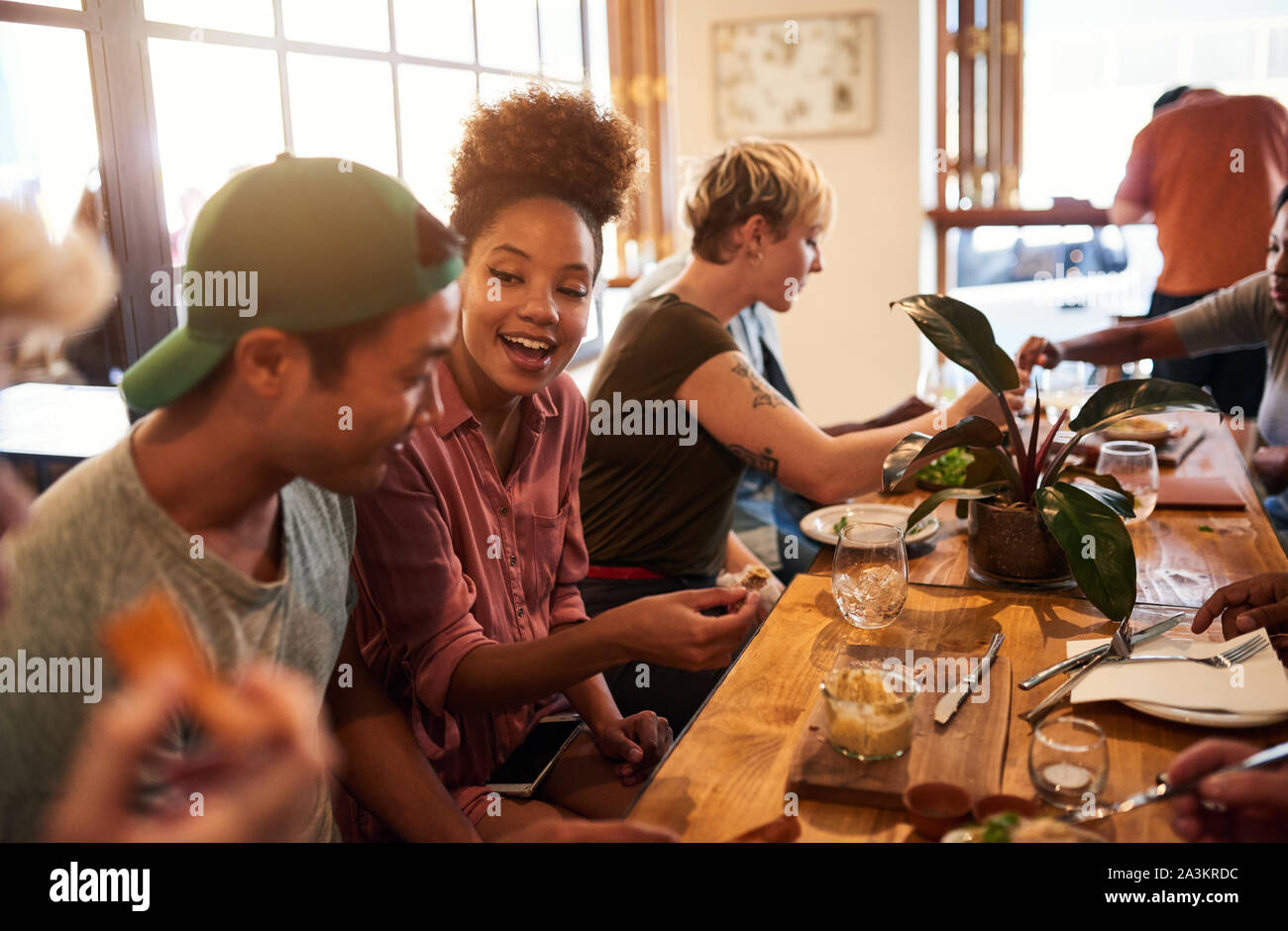 Lächelnd Gruppe von diversen Freunden sprechen über das Mittagessen zusammen Stockfoto
