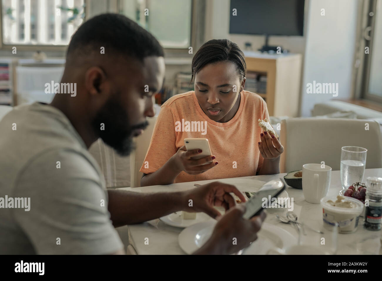 Junge Afrikanische Amerikanische Ehepaar Mit Ihren Handys Uber Fruhstuck Abgelenkt Stockfotografie Alamy