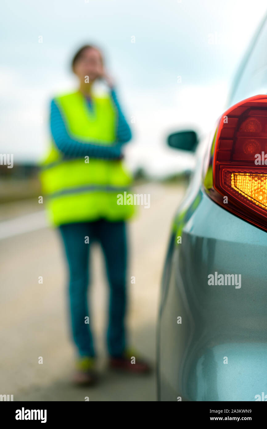 Aufschlüsselung des Fahrzeugs auf der Straße, Frau mit Telefon, um Hilfe zu bitten und Pannenhilfe Stockfoto
