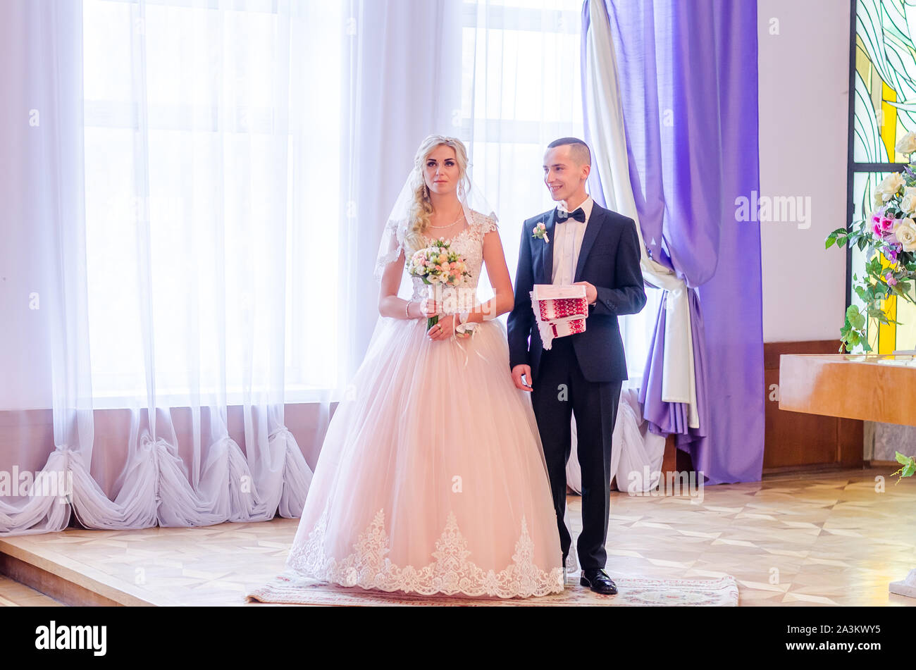 Braut und Bräutigam am Hochzeitstag zu Fuß im Freien auf Frühling Natur. Brautpaar, gerne frisch verheiratete Frau und Mann umarmen im Green Park. Liebe Hochzeit Stockfoto