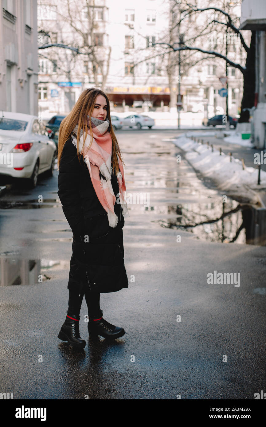 Junge Frau trägt warme Kleidung auf der Straße im Winter Stockfoto