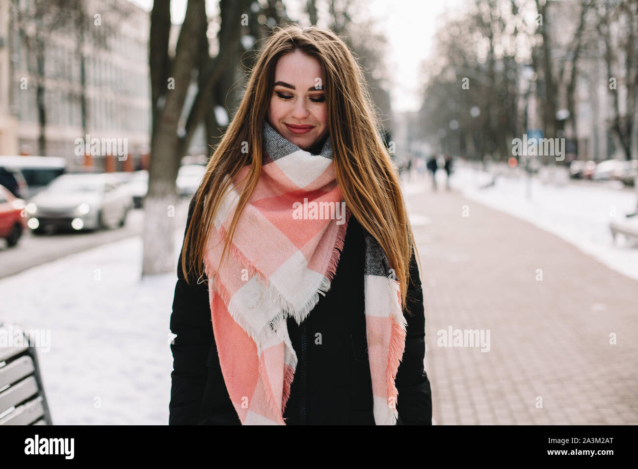 Junge Frau trägt warme Kleidung auf der Straße im Winter Stockfoto
