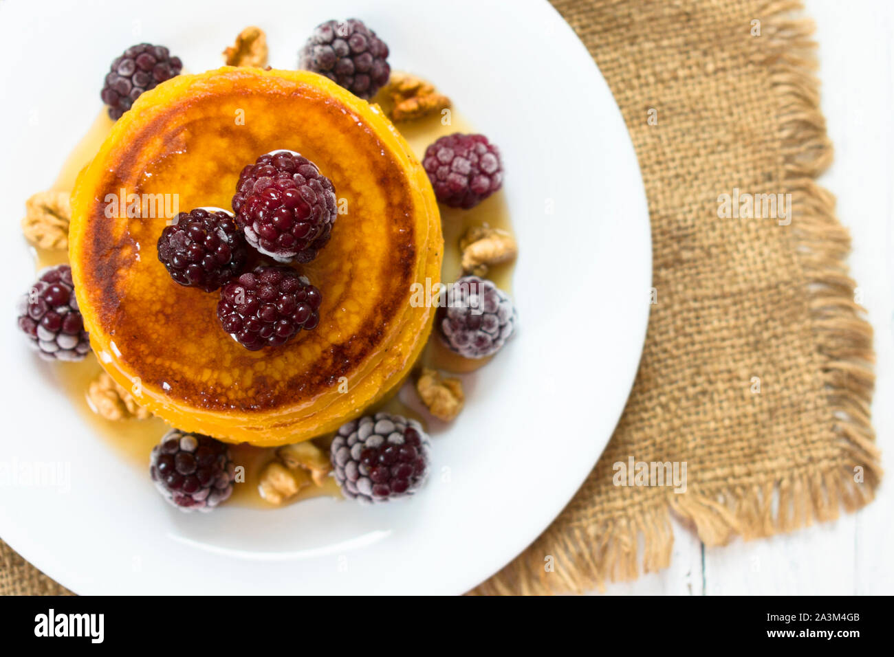 Kürbis Pfannkuchen mit Ahornsirup, Beeren und Nüsse. Am Ende der Saison (Herbst) Frühstück. Ansicht von oben. Stockfoto