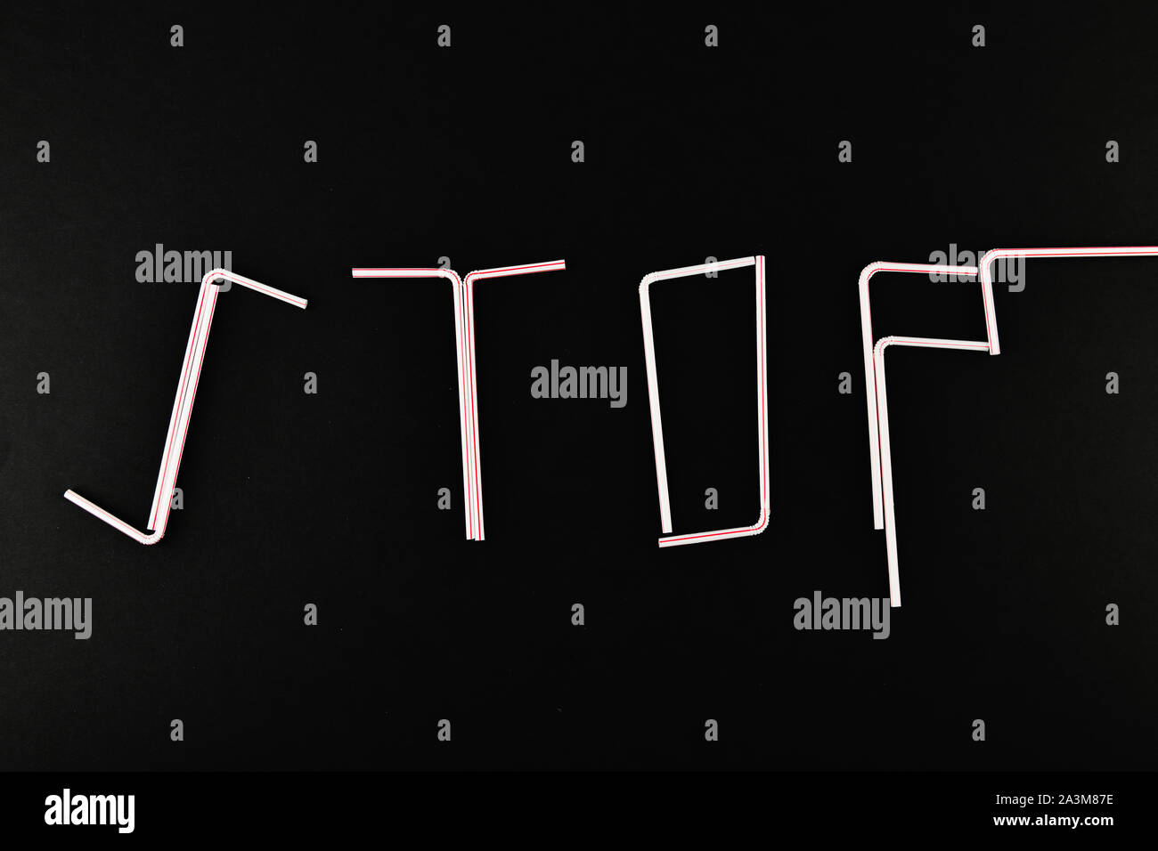 Stop Kunststoff. aus Kunststoff das Wort Stop. Das Wort STOP von Kunststoffrohren auf einem schwarzen Hintergrund mit leeren Raum für Text. Blick von oben. Stockfoto