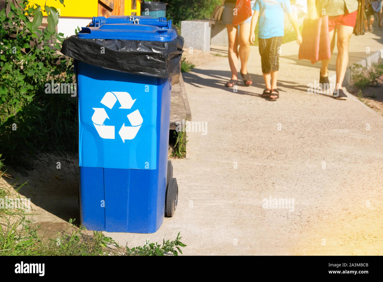 Garbage Collection. Recycling von Abfällen Konzept. Den blauen Container für die weitere Verarbeitung von Müll. Sonnenschein. Stockfoto