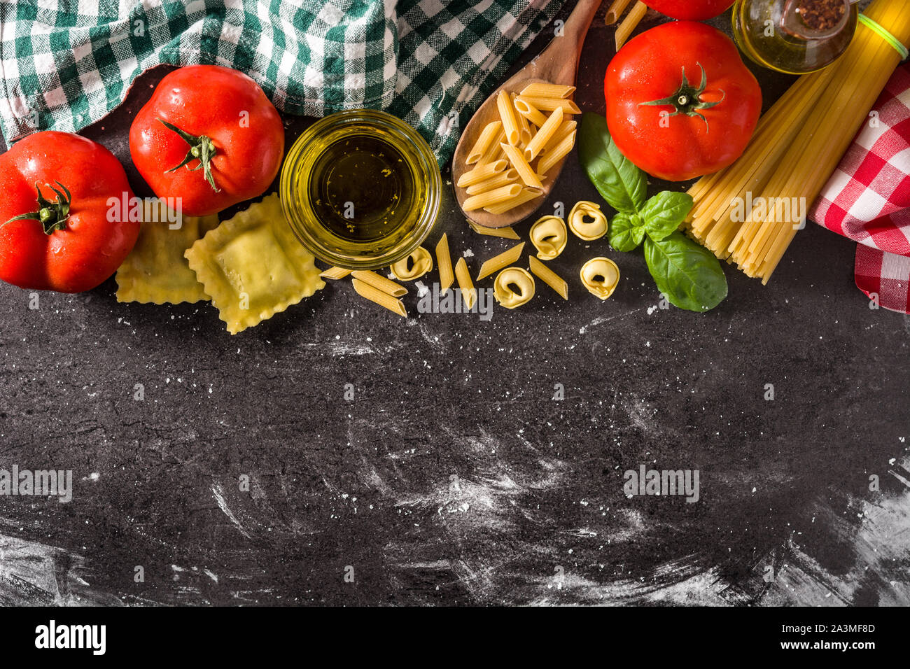 Italienische Pasta und Zutaten. Ravioli, Nudeln, Spaghetti, Tortellini, Tomaten und Basilikum Stockfoto