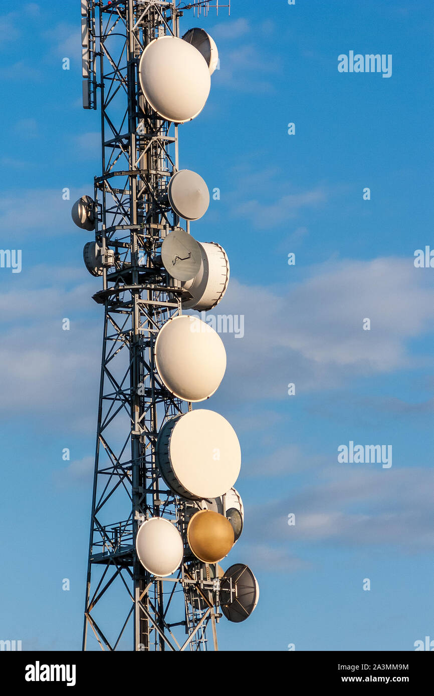 Fernmeldeturm, Antenne und Satellitenschüssel mit blauen Himmel im Hintergrund. Stockfoto