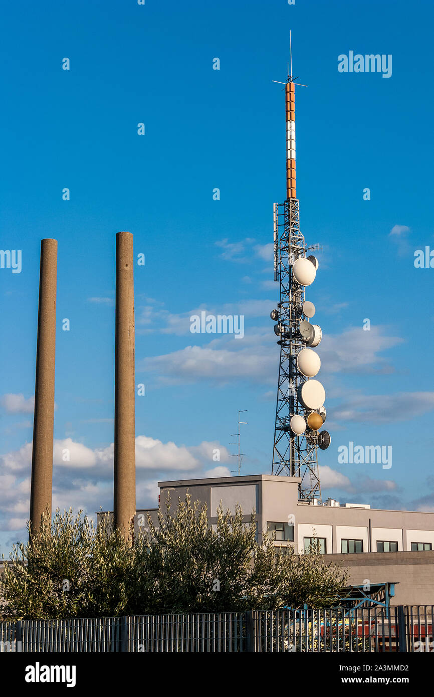 Städtische Szene mit Tk-Turm und Industrieschornsteinen. Stockfoto