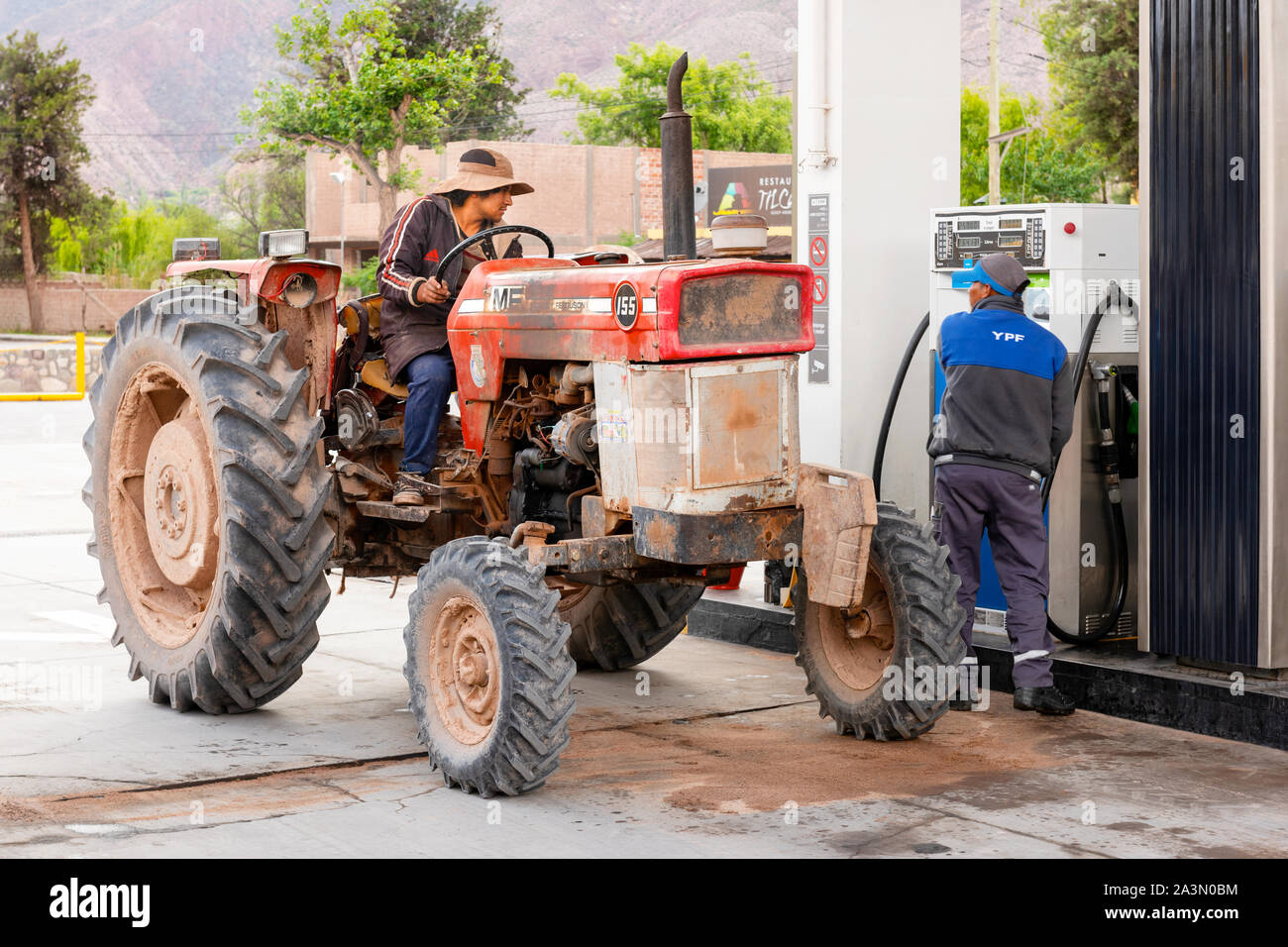 Eine Farm Traktor Nachfüllpackungen mit Diesel zu einem YPF-Tankstelle in Tilcara, nördliche Argentinien. Stockfoto