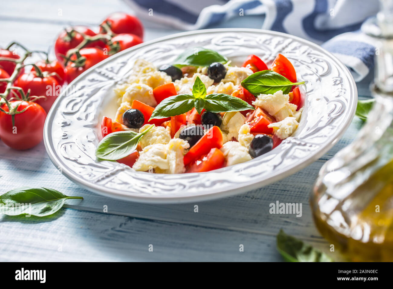Caprese Salat mit Mozzarella Käse frische Tomaten Oliven und Basilikum. Italienischen oder mediterranen gesunde Mahlzeit Stockfoto