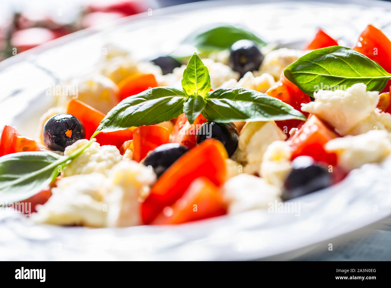 Caprese Salat mit Mozzarella Käse frische Tomaten Oliven und Basilikum. Italienischen oder mediterranen gesunde Mahlzeit Stockfoto