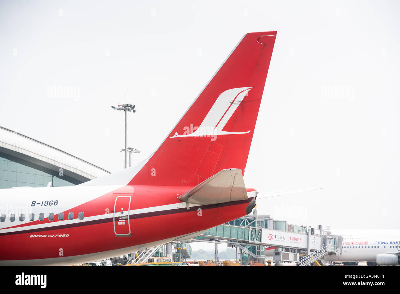 Logo von Shanghai Airlines mit einer Boeing 737-800 in Guangzhou Baiyun International Airport. Stockfoto