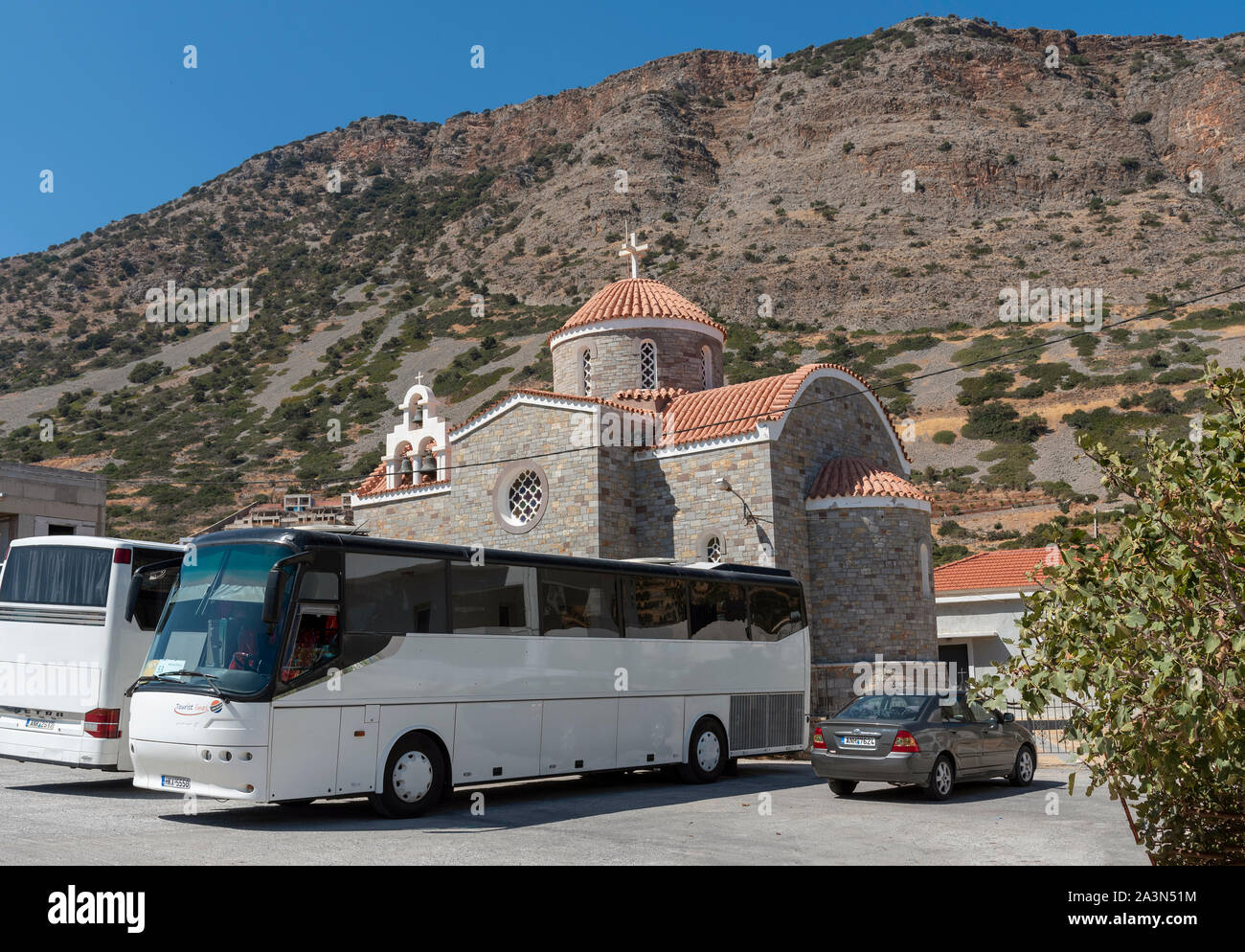 Plaka, Kreta, Griechenland. Oktober 2019. Busse für Touristen außerhalb eines großen modernen Kirche in Plaka, Kreta, Griechenland warten Stockfoto