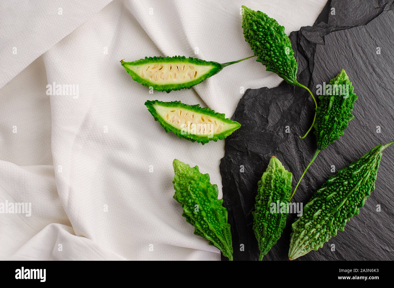 Momordica Obst oder balsam Apfel auf schwarzen und weißen Hintergrund mit kopieren. Flach, Ansicht von oben Stockfoto