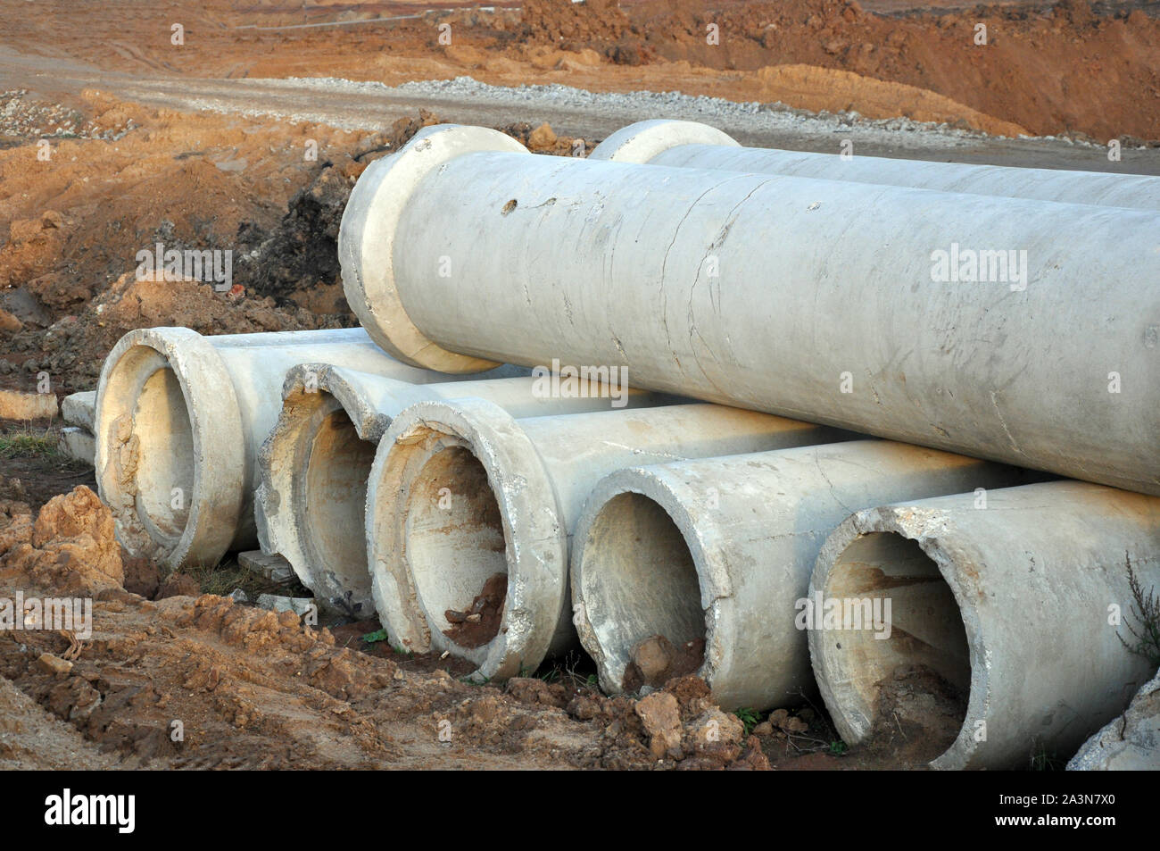 Ein Blick auf zwei Reihen von Zement oder Beton Boden Rohre auf dem Boden liegend, verwendet der Abwasser- und Wasserleitungen zu erstellen Stockfoto