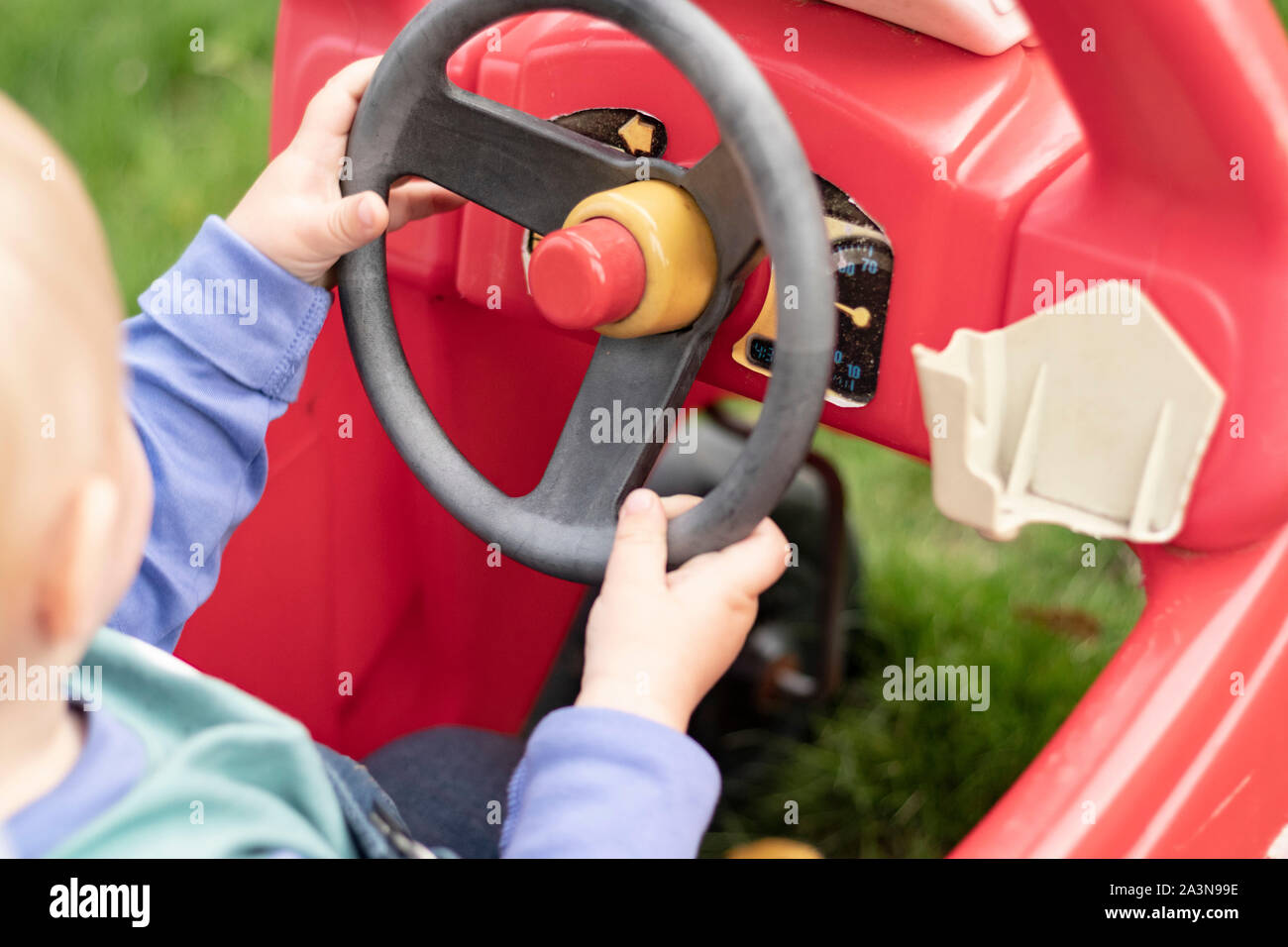 Kleines Kind mit Händen am Lenkrad des Spielzeugautos Stockfotografie -  Alamy