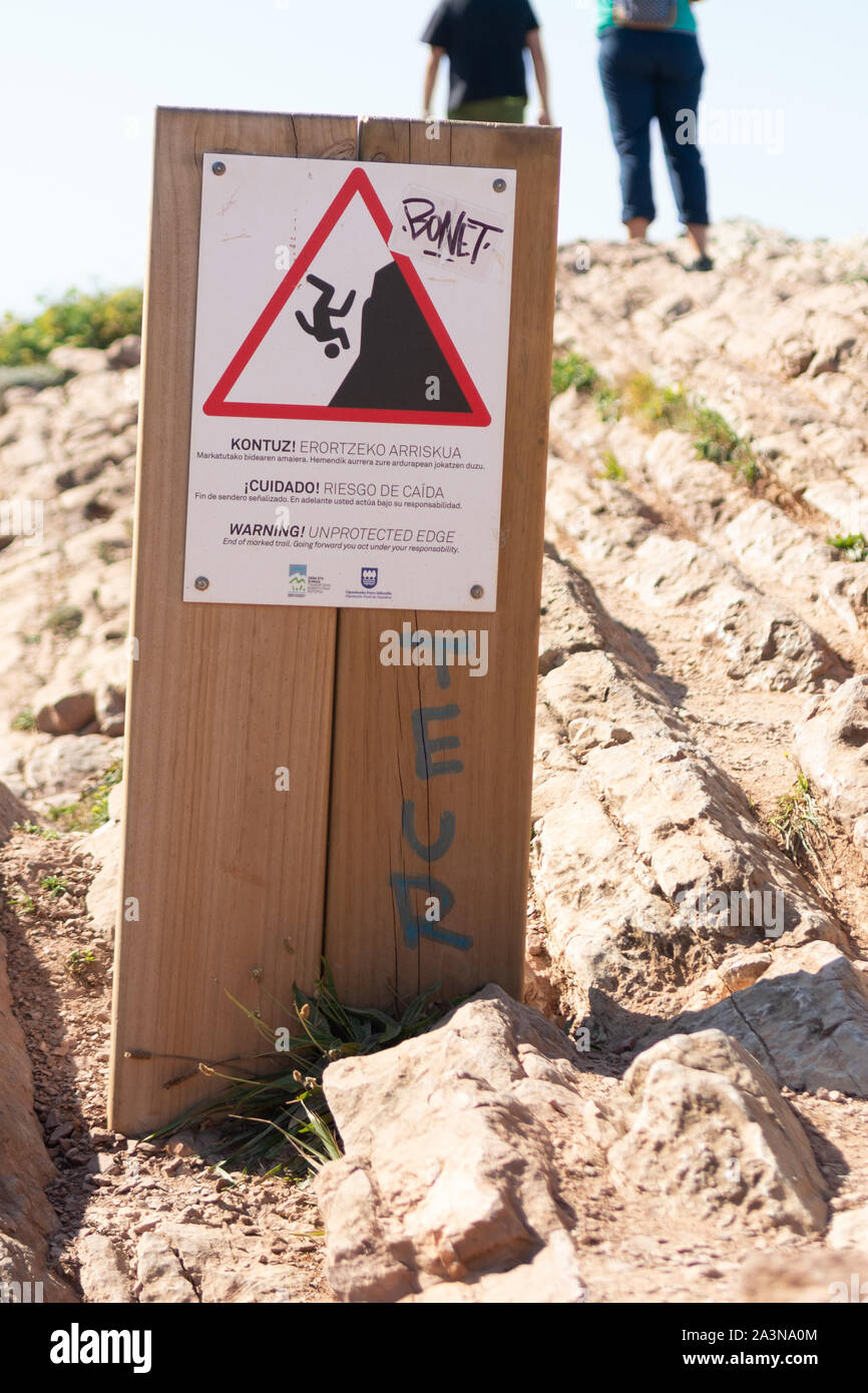 Warnzeichen für eine ungeschützte Flanke auf Klippen oberhalb Algorri Strand, La Ravoire, Gipuzkoa, Baskenland, Spanien, Europa Stockfoto