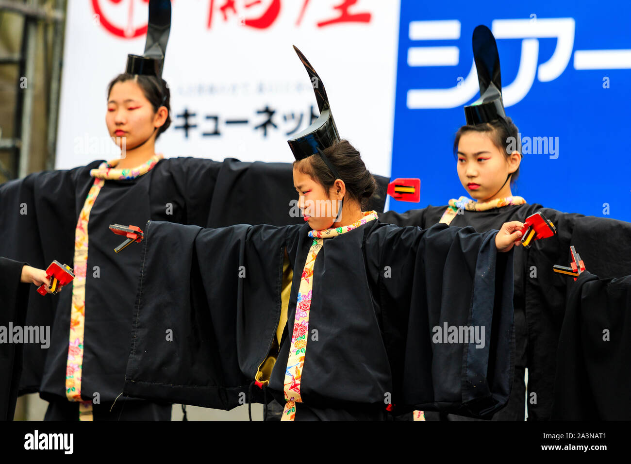 Japanische Kyusyu Gassai Festival in Kumamoto. Erwachsene und Kinder Yosakoi Tänzer in schwarzen Kostümen und eboshi Hüte, auf der großen Bühne tanzen. Tagsüber. Stockfoto