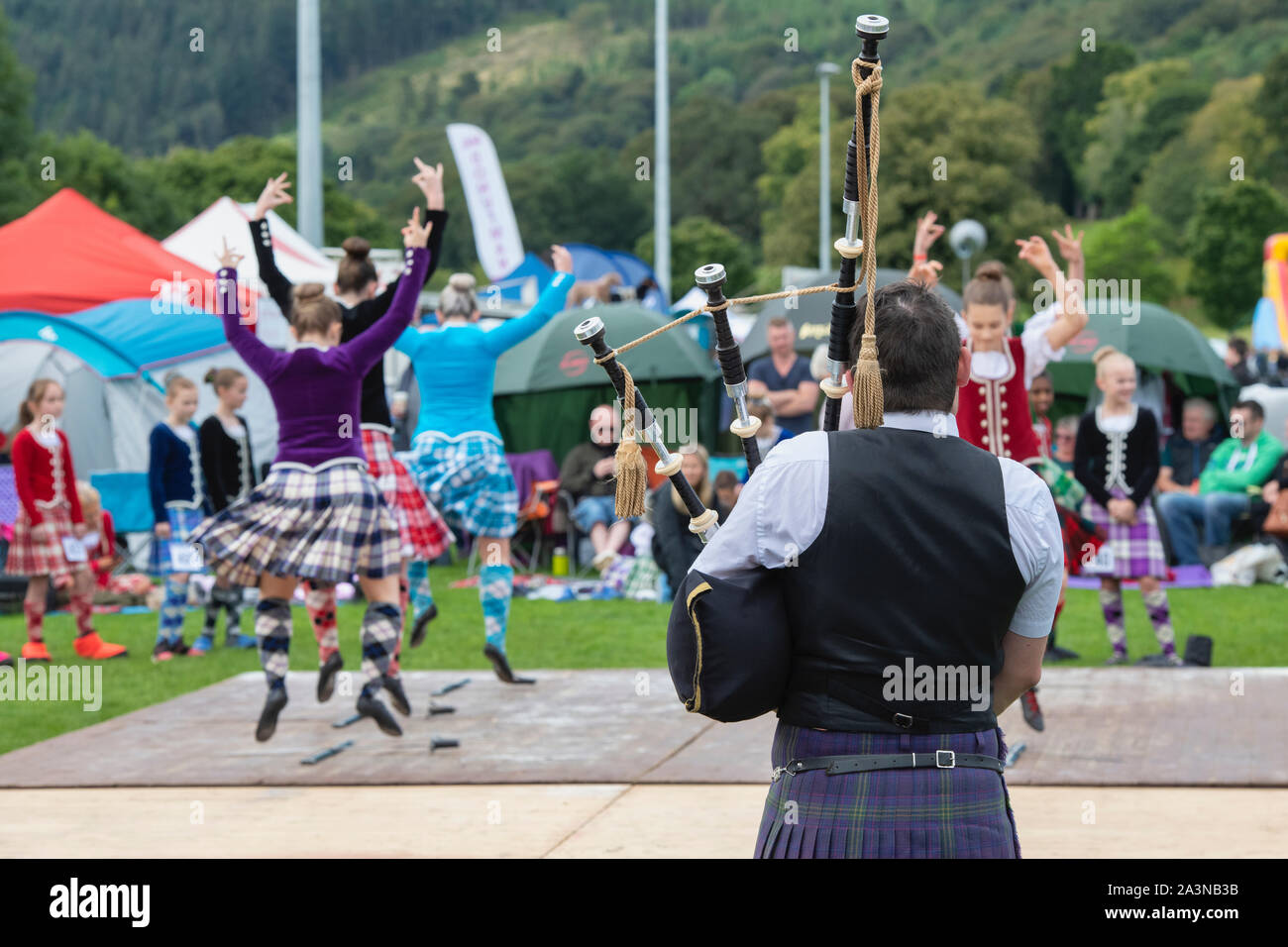 Piper und Highland Dancing Girls in der Highland Games in Peebles. Peebles, Scottish Borders, Schottland Stockfoto