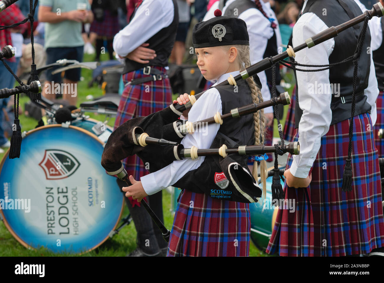 Junge Mädchen in der Preston Lodge High School Pipe Band holding Dudelsack in Peebles highland games. Peebles, Scottish Borders, Schottland Stockfoto