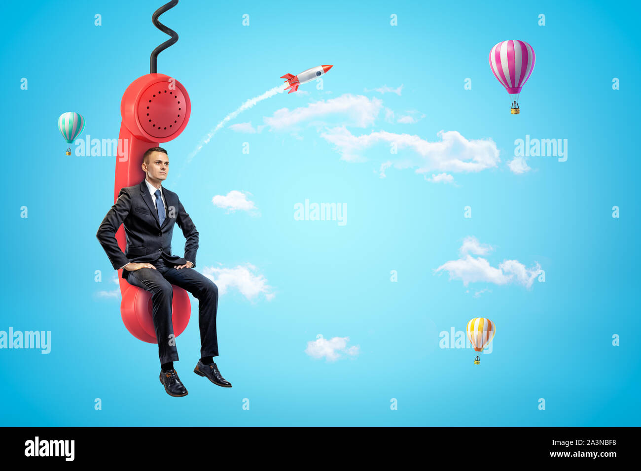 Junge Unternehmer sitzen auf roten Telefonhörer in blauer Himmel mit Heißluftballons und Rakete im Hintergrund. Stockfoto