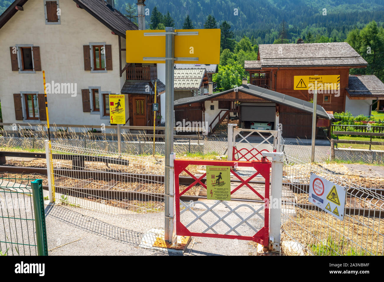 Fußgängerüberfahrt über die Eisenbahn mit Indikatoren der Todesgefahr durch Stromschlag in Chamonix, Frace Stockfoto Fußgängerüberfahrt über die Eisenbahn mit Indikatoren der Todesgefahr durch Stromschlag in Chamonix, Frace Stockfoto