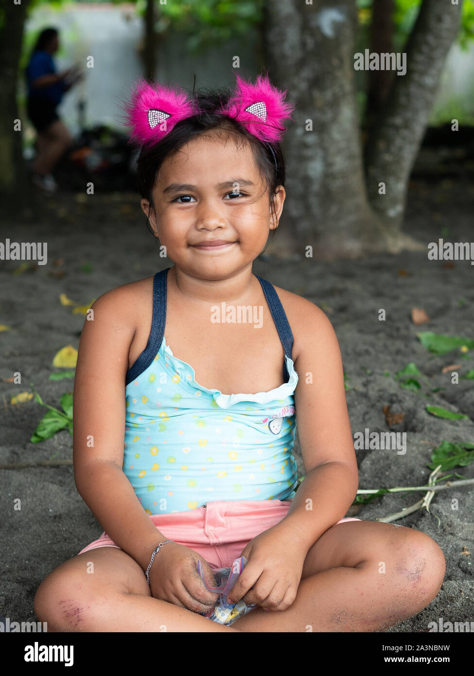 Kleines Mädchen Porträt auf dem Sand sitzen Stockfoto