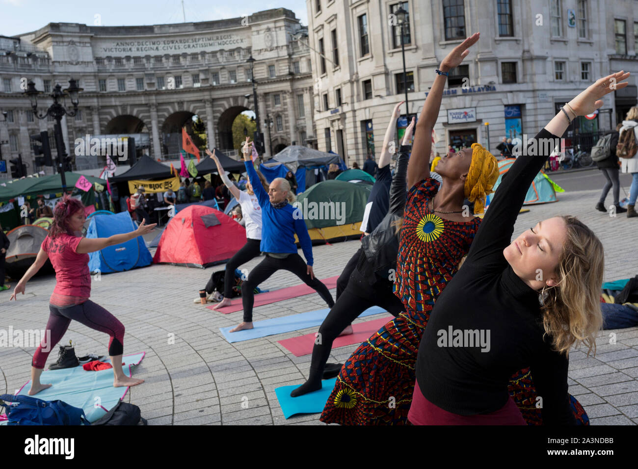Umweltaktivisten Yoga während Protest über den Klimawandel während einer Besetzung des Trafalgar Square in Central London, ist der dritte Tag der zwei Wochen anhaltenden weltweiten Protest von Mitgliedern des Aussterbens Rebellion, am 9. Oktober 2019, in London, England. Stockfoto