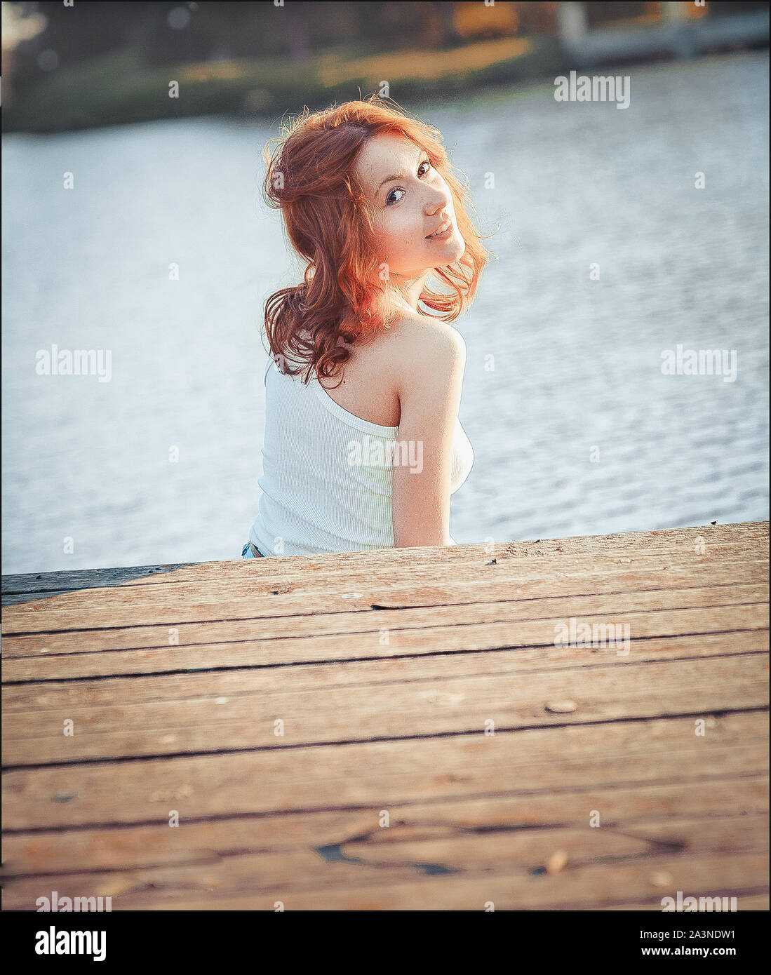 Mädchen an der hölzernen Pier. Junge fröhliches Mädchen. Meer und Himmel Hintergrund. Urlaub, Reisen und Freiheit Konzept. Stockfoto