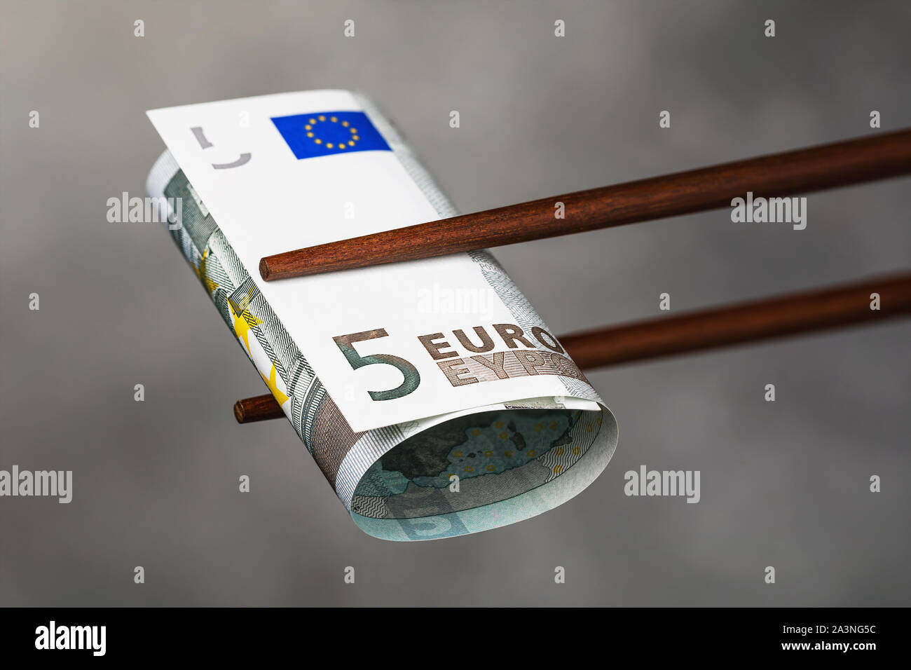 Chinese sticks halten fünf Euro. Konzept zum Thema wirtschaftliche Konfrontation zwischen der Europäischen Union und China. Die Beziehungen zwischen den Ländern Stockfoto