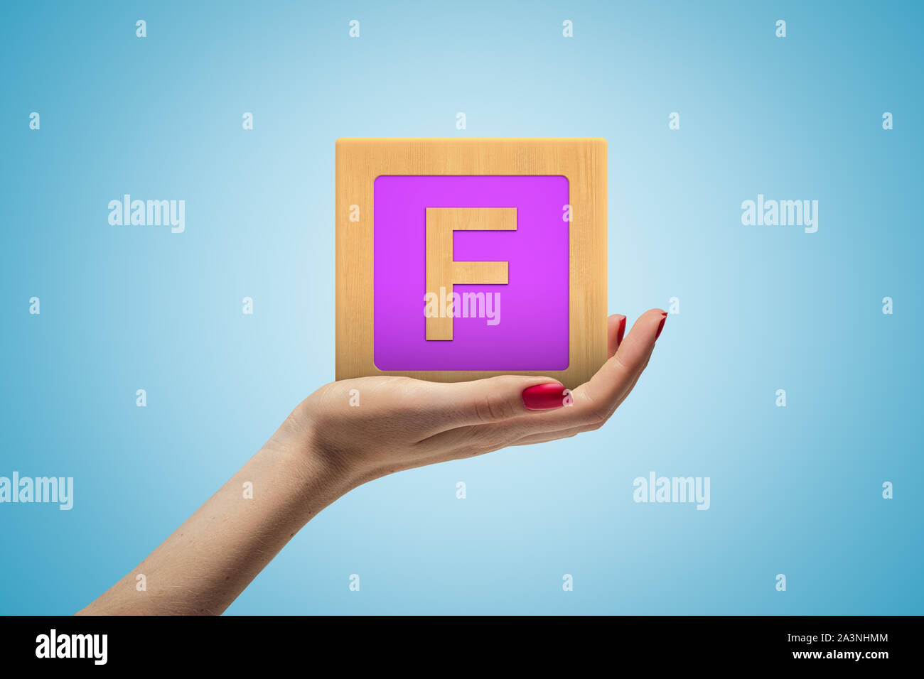 Weibliche Hand alphabet Spielzeug Block auf blauem Hintergrund Stockfoto