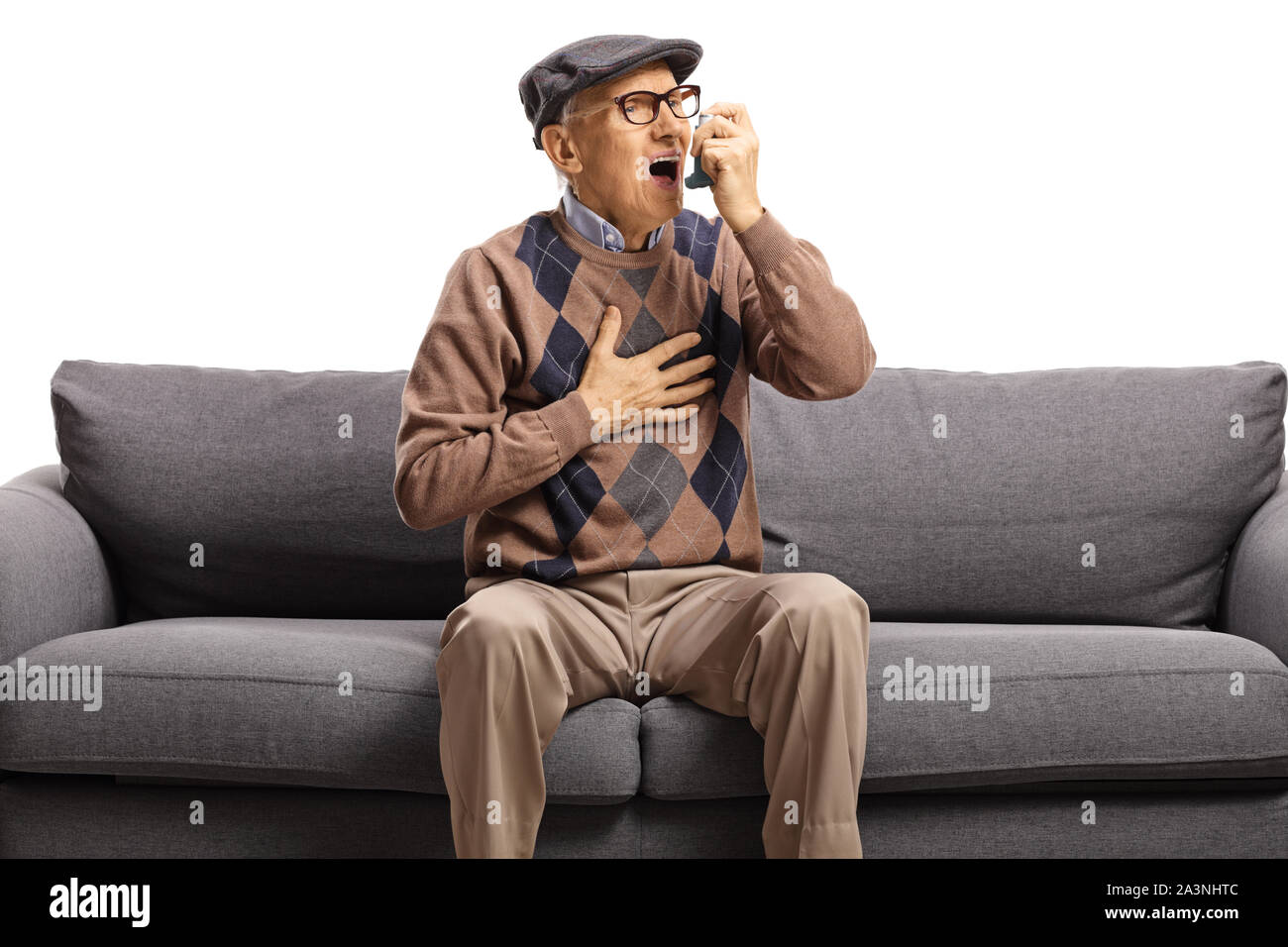 Ältere Mann sitzt auf einem Sofa und mit einem Inhalator auf weißem Hintergrund Stockfoto