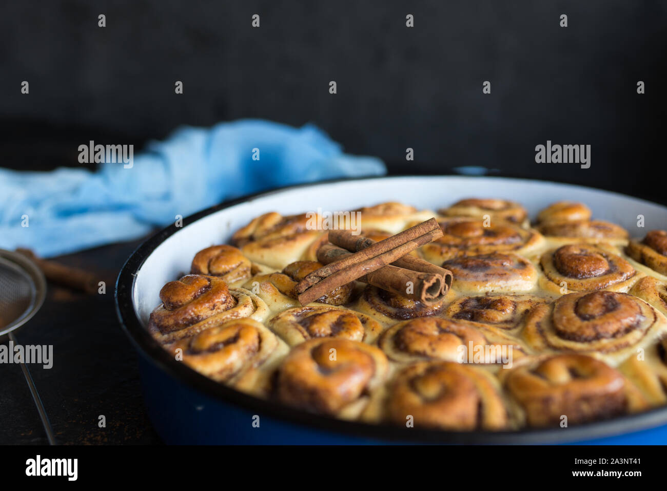 Cinnamon Roll Tarte mit Zuckersirup in vintage Backblech auf schwarzem Hintergrund Stockfoto