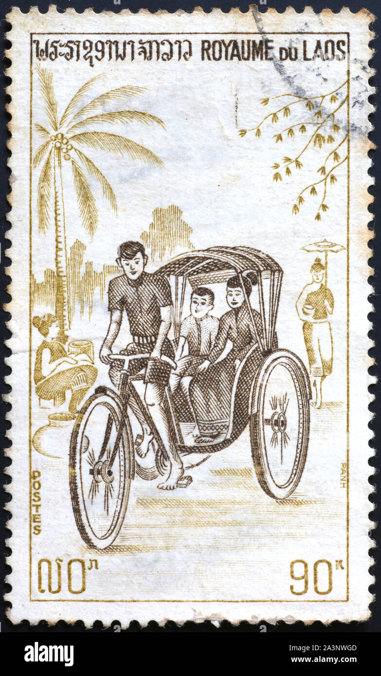 Cycle rickshaw auf Briefmarke Laos. Stockfoto
