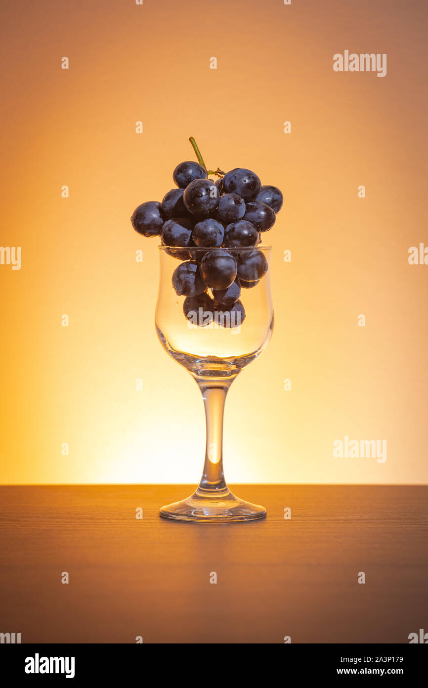 Konzeptionelle Idee der Trauben in den Wein Glas als Rohstoffe anstelle von Endprodukt Stockfoto