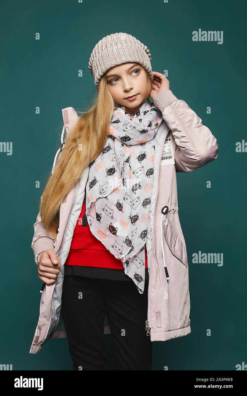 Glückliches Mädchen tragen in Jeans, Stiefel, eine warme Jacke und Hut. 7/8-Porträt einer jungen blonden Model girl in der modischen Winterkleidung Posing über die Stockfoto