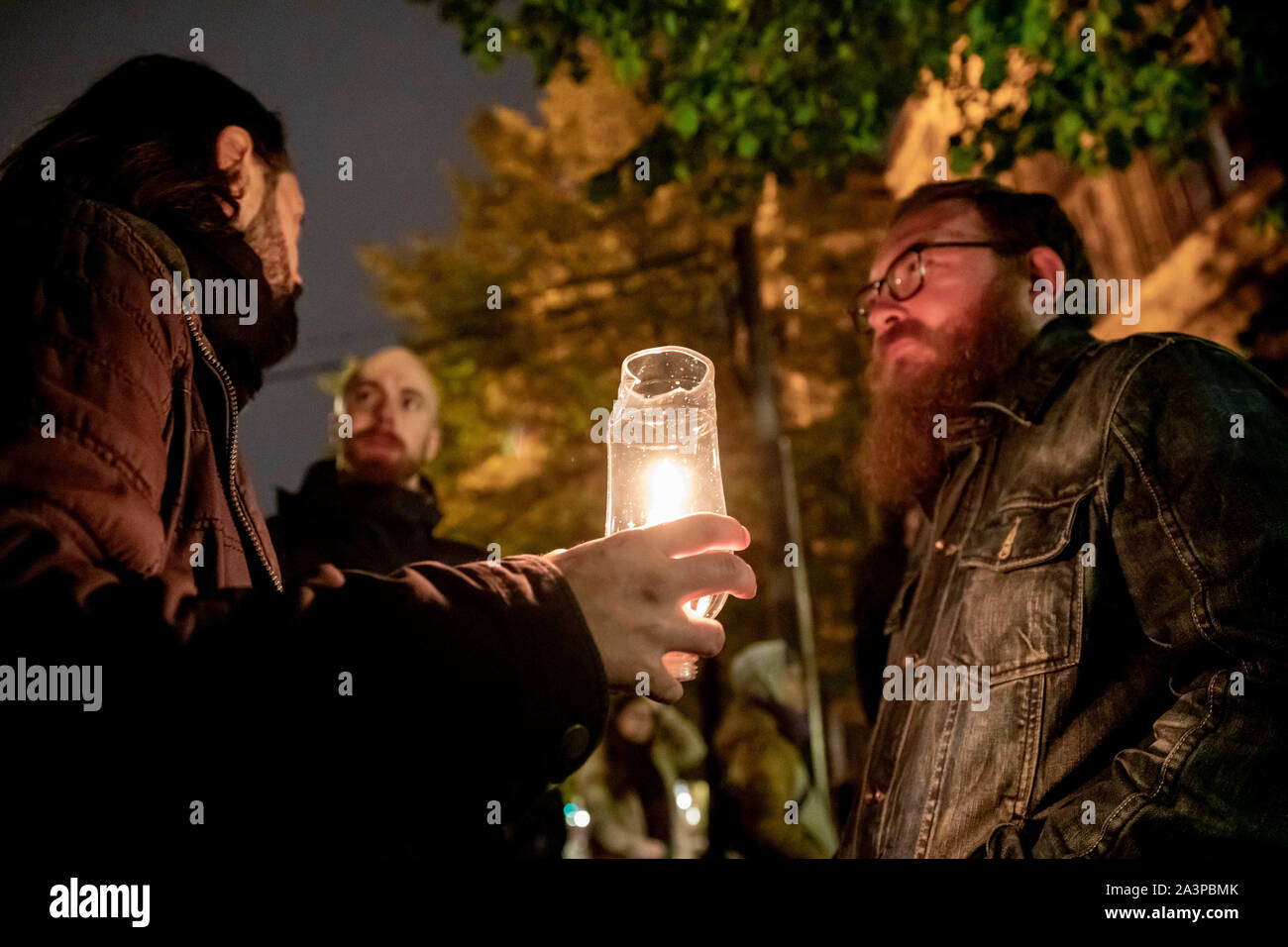 Berlin, Deutschland. 09 Okt, 2019. Drei Männer stehen an einem Solidarität Demonstration anlässlich der Ermordung in Halle (Saale) in die Neue Synagoge Berlin, einer Holding eine Kerze. (Abgebildet sind Guido (L-R), Marcel und Constantin, bitte keine Namen nennen) Credit: Christoph Soeder/dpa/Alamy leben Nachrichten Stockfoto