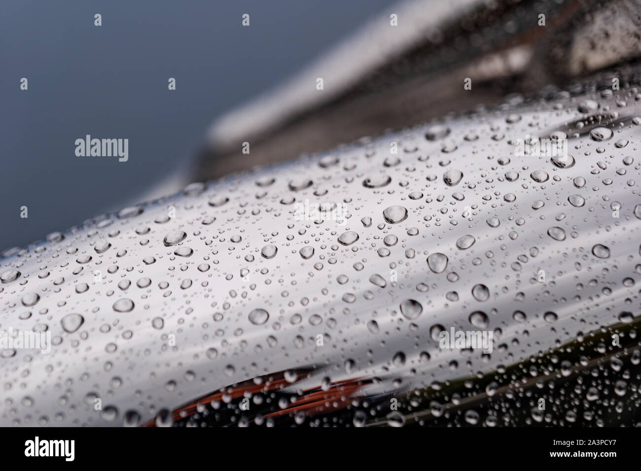 Nahaufnahmen und Makro Aussicht auf regen Wassertropfen auf glänzend poliert Krümmung verchromte Oberfläche der abstrakten Skulptur. Stockfoto