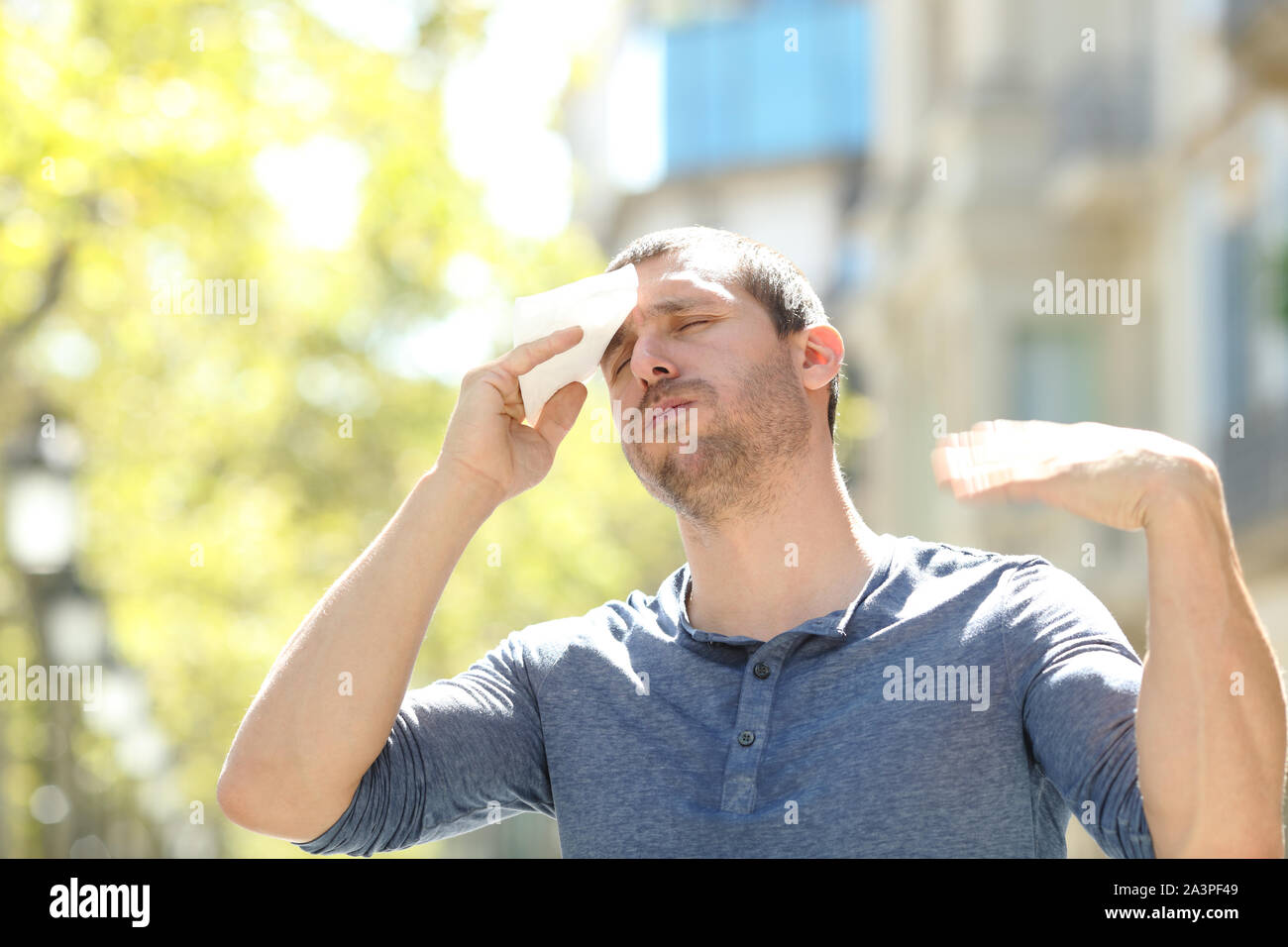 Betont man Schwitzen und Trocknen mit einem Wisch leiden Hitzschlag ein warmer Tag im Sommer auf der Straße Stockfoto