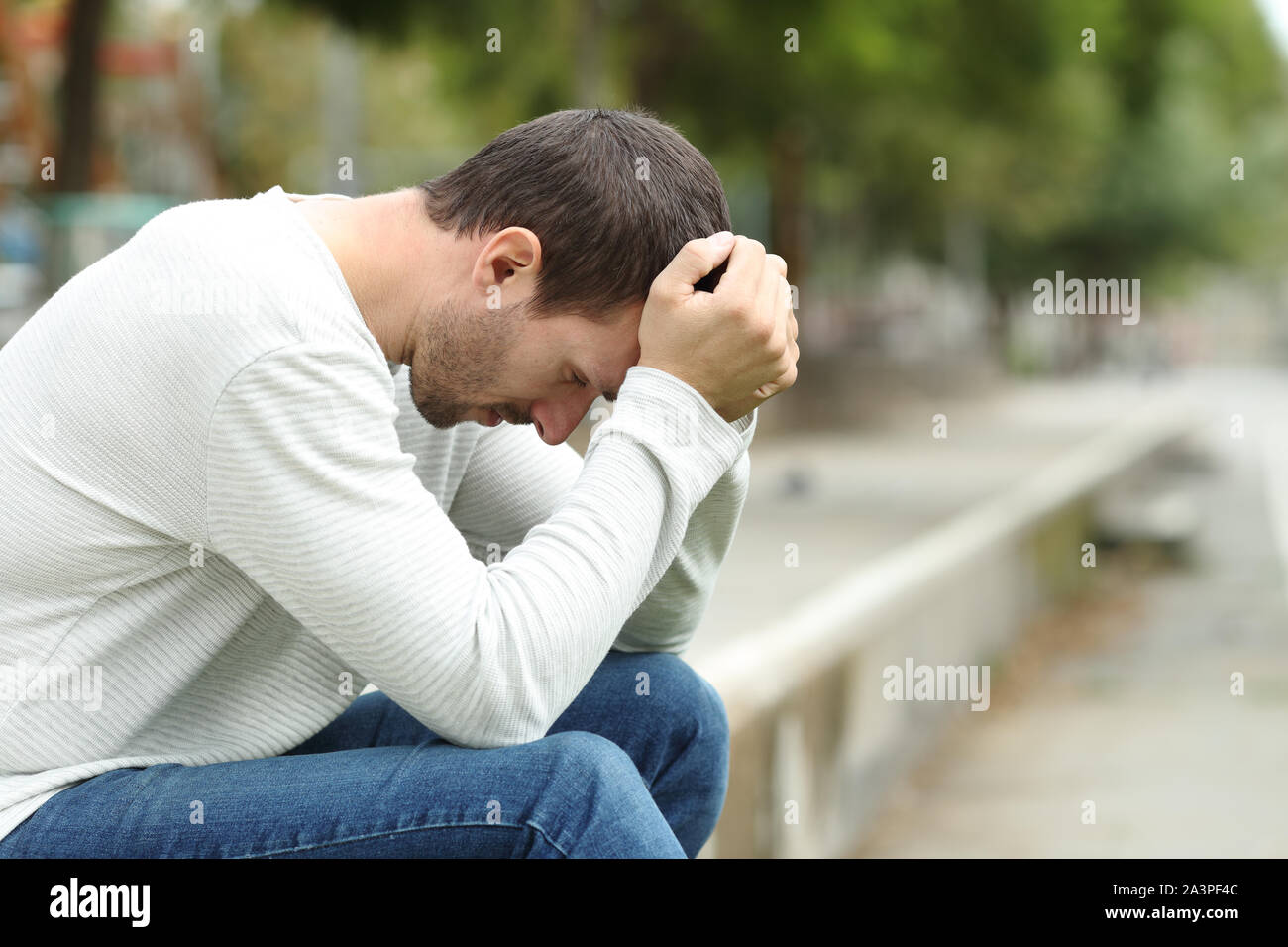 Seitenansicht Porträt eines traurigen erwachsenen Mann allein in einem Park Beschweren Stockfoto