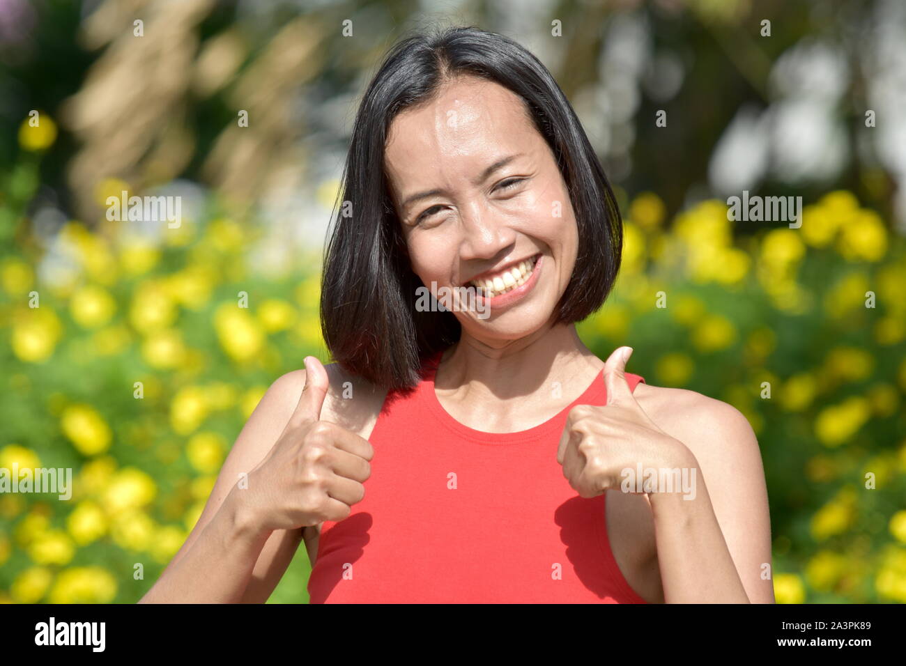 Schöne asiatische Frau mit Daumen hoch Stockfoto