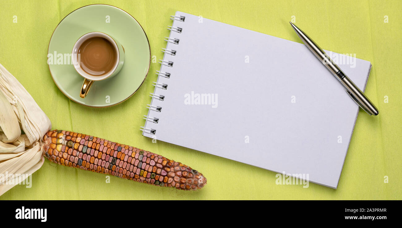 Leere Spirale Art Skizzenbuch gegen Strukturierte krepp papier mit dekorativen Mais und Kaffee, Herbstferien Grußkarte Konzept Stockfoto