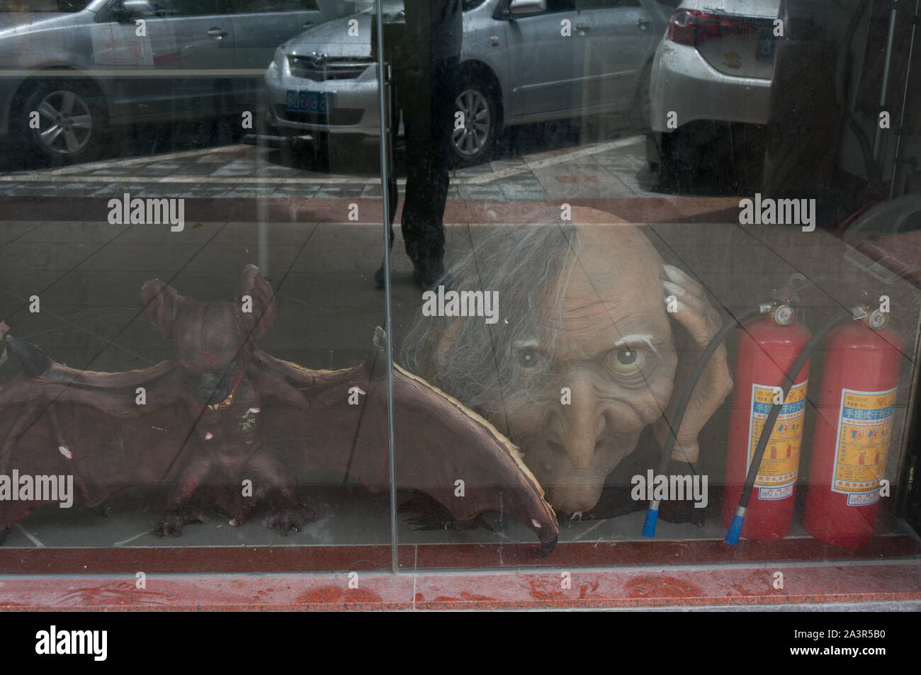 Spooky Halloween Monster Kopf hinter staubigen Fenster gesehen Stockfoto